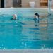 Senior woman and adult woman enjoying a relaxing swim in an indoor pool, featuring leisure and relaxation.